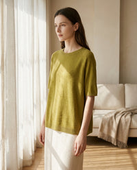 Pull en laine mérinos vert olive porté dans un intérieur lumineux - StudioSoie