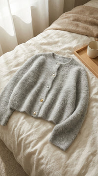 Cardigan en alpaga en flat-lay sur lin crème - StudioSoie